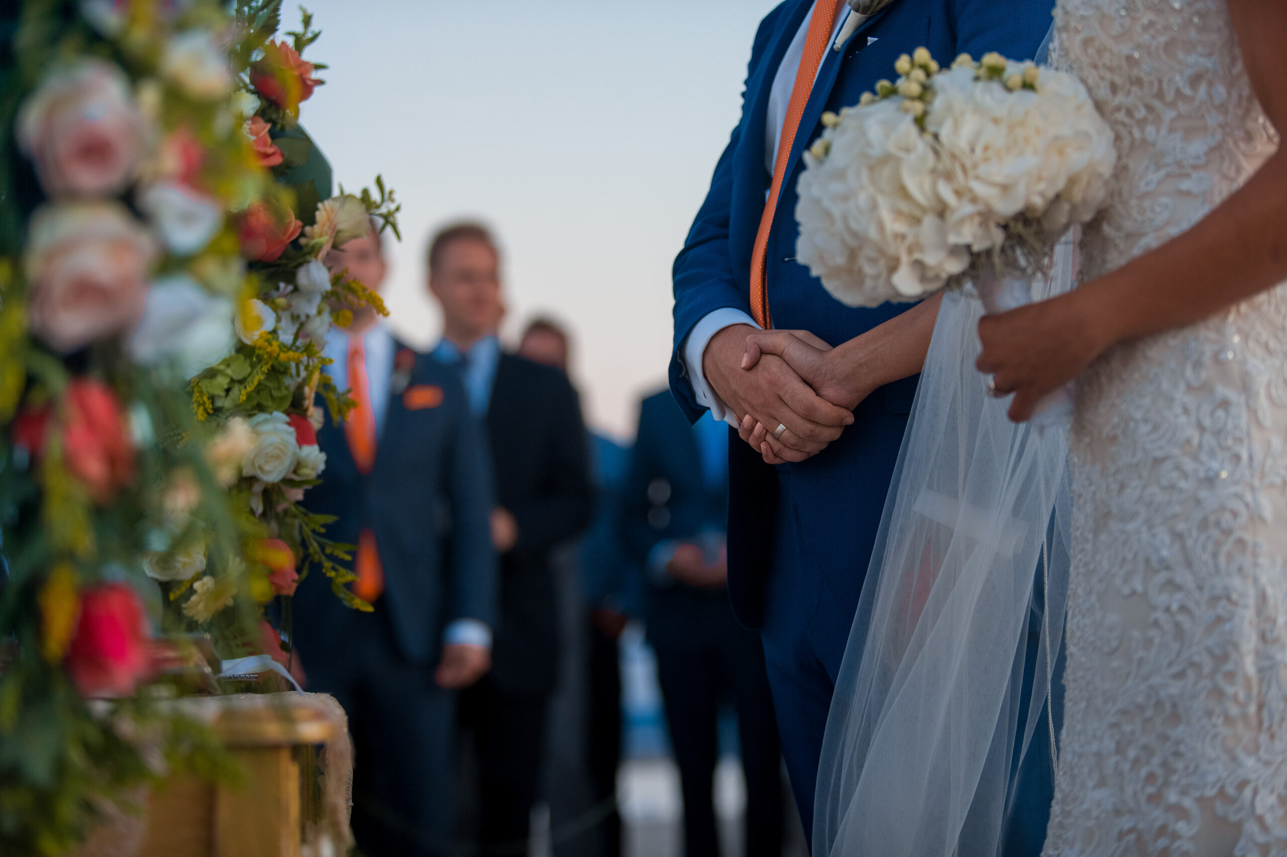 Bride in dress with crystals stands with bouquet in her hands